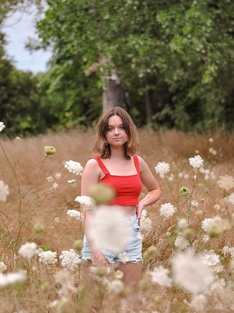 Young girl standing in a field of wildflowers